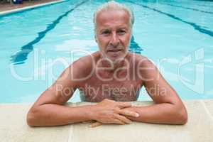 Senior man leaning on poolside