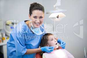 Dentist examining a young patient with tools in dental clinic