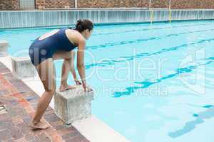 Female swimmer preparing to dive in pool