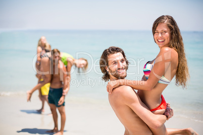 Young man lifting woman at beach