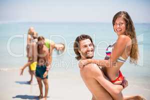 Young man lifting woman at beach