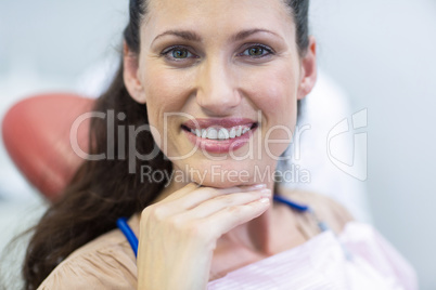 Smiling female patient sitting on dentist chair