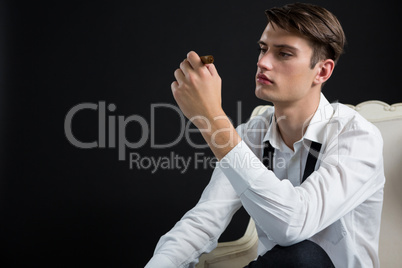 Androgynous man looking at cigar
