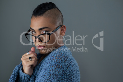transgender woman wearing eyeglasses against gray background