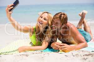 Couple smiling while taking selfie at beach