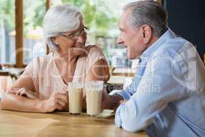 Happy senior couple interacting while having coffee