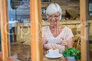 Senior woman photographing a coffee cup
