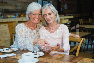 Two senior women using mobile phone