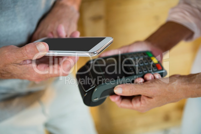 Customer making payment through NFC technology on mobile phone