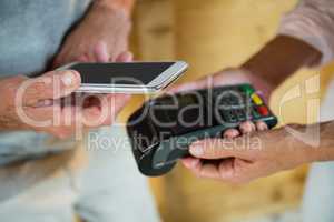 Customer making payment through NFC technology on mobile phone