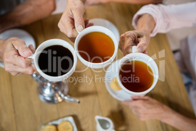 Group of senior friends toasting coffee cups