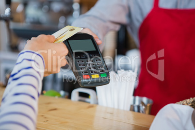 Woman making payment through credit card at counter