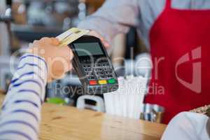 Woman making payment through credit card at counter