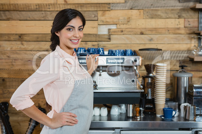 Portrait of waitress standing with hand on hip