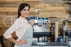 Portrait of waitress standing with hand on hip