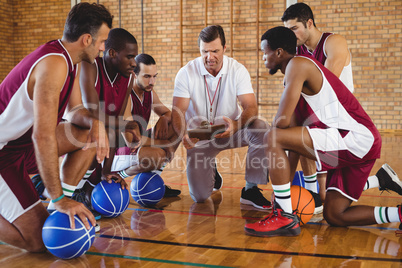 Coach explaining game plan to basketball players