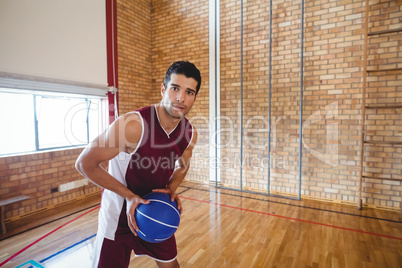 Basketball player holding basketball in the court