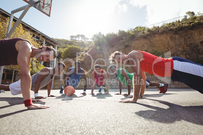 Basketball players performing push up exercise