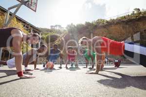 Basketball players performing push up exercise