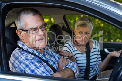 Annoyed senior cpouple sitting in car