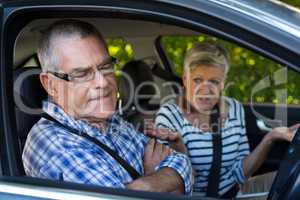 Annoyed senior cpouple sitting in car