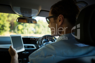 Man using digital tablet in car
