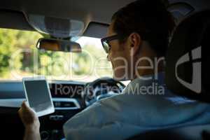 Man using digital tablet in car