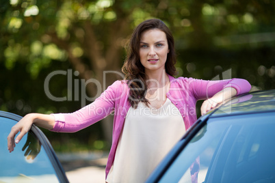 Confident woman standing by car