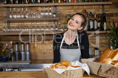 Portrait of cheerful owner standing by counter