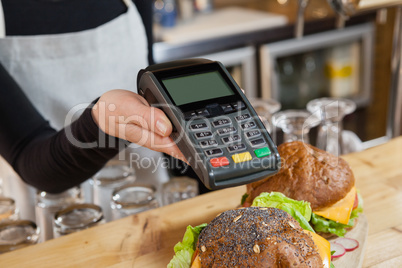 Close up of owner holding credit card reader