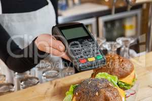 Close up of owner holding credit card reader