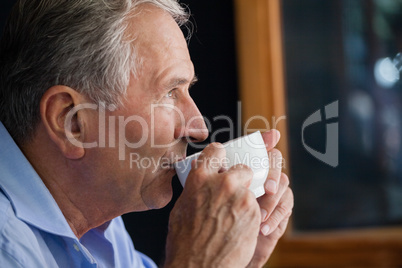 Senior man drinking coffee at cafe shop