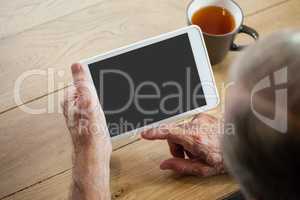 High angle view of man using digital tablet while sitting at table