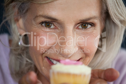 Close up portrait of woman holding cupcake