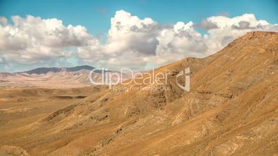 Timelapse clouds and shadows fly over a dry landscape in Fuerteventura, Canary Islands, Spain