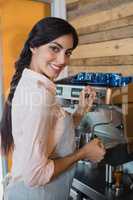 Portrait of waitress using coffeemaker