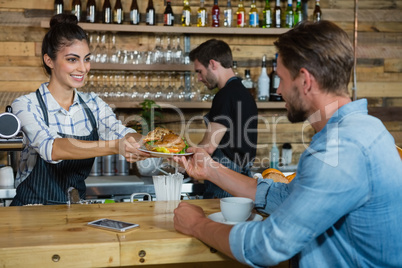 Waitress serving breakfast to man at counter