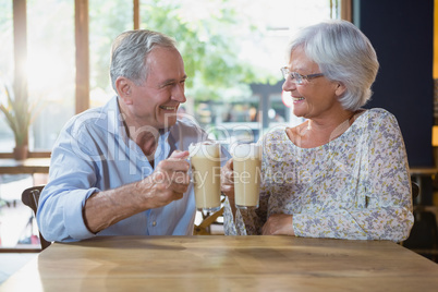 Senior couple toasting glasses of cold coffee