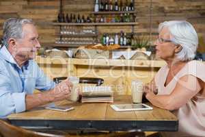 Senior couple interacting while having coffee