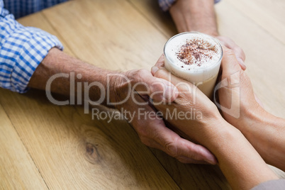 Senior couple holding hands in outdoor cafÃ?Â©