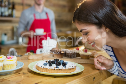 Woman looking at tart dish in cafÃ?Â©