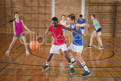 High school kids playing basketball in the court