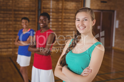High school kids standing with arms crossed in the basketball court