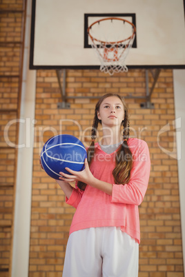 Determined girl holding a basketball