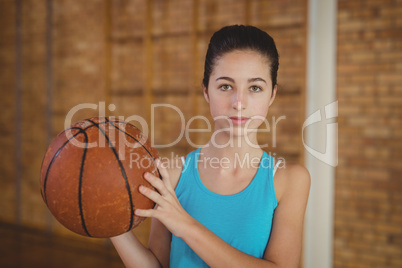 Determined girl holding a basketball