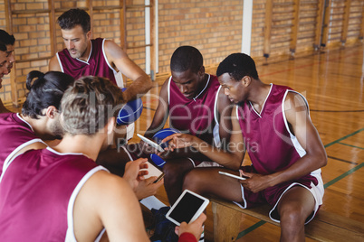 Basketball players talking while using digital tablet