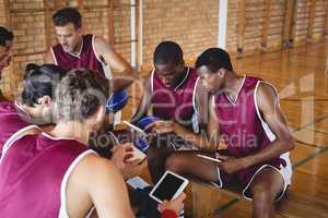 Basketball players talking while using digital tablet