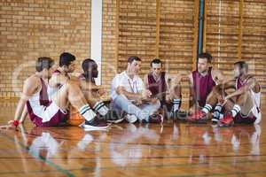 Coach explaining game plan to basketball players