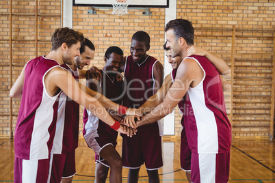 Team of basketball players stacking hands