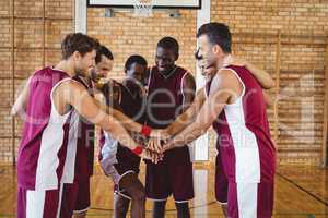 Team of basketball players stacking hands